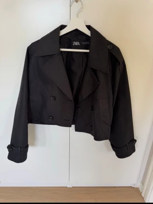 Kort svart trenchcoat från Zara - Snygg kort svart trenchcoat från Zara i storlek L. Köpt på vinted men va för stor tyvärr. Aldrig använd❤️