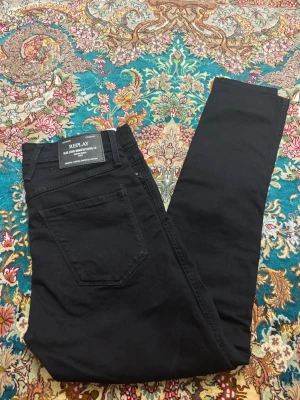 Replay jeans - Snygga svarta skinny jeans från Replay med klassisk femficksdesign och diskret logga på bakfickan. Jeansen har hög midja och är tillverkade i ett stretchigt bomullsmaterial för skön passform. Perfekta för en trendig och stilren look. Helt ny med prislapp kvar.