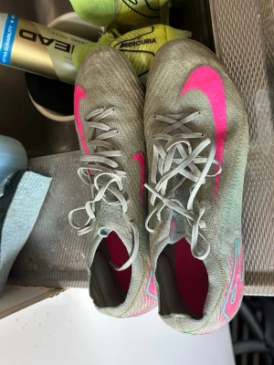 fotbollsskor med rosa detaljer - Dessa skorna är högsta kvaliten. Skruvdubbar. De är använda men med det priset jag säljer de för är de väldigt värt att köpa de.