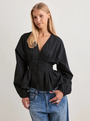 Svart v-ringad blus med knappar - Stilren svart blus med v-ringning och dekorativa knappar framtill. Blusen har lång ärm med volym och markerad midja som ger en snygg siluett. Perfekt att matcha med jeans eller kjol för en trendig look. Helt ny med prislapp kvar🤍