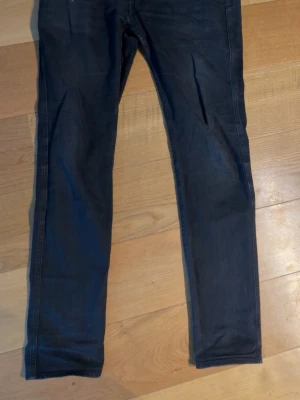 Replay anbass - Snygga svarta slim fit jeans med klassisk femficksdesign och smala ben. Jeansen har en lätt tvättad look och raka sömmar längs benen. Perfekta för dig som gillar en enkel och stilren stil.