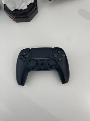Svart Sony DualSense PS5 handkontroll - Säljer min svarta Sony PlayStation 5 DualSense-kontroll i nyskick. Den är felfri och fungerar perfekt utan några som helst problem eller skavanker.  Jag köpte kontrollen ny för cirka två månader sedan. Den har dock bara varit aktivt använd under en enda månad. Anledningen till försäljningen är att jag kort efter köpet gick över till att spela på PC, där denna kontroll tyvärr bara blivit liggande oanvänd. Det känns därför bättre att någon annan får nytta av den. Detta är ett p