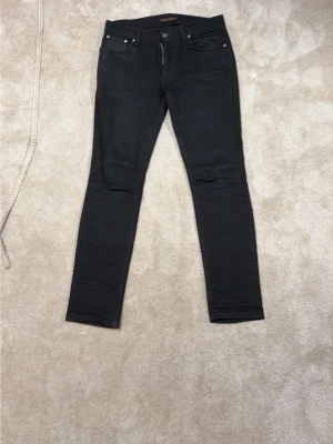 Svarta slim fit jeans från Nudie Jeans - Snygga svarta slim fit jeans från Nudie Jeans. Fint skick men man ser att dom är andvända. Skriv om du har frågor eller liknande!