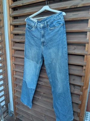 Loose straight jeans från H&M - Säljer ett par blå loose straight jeans från H&M:s The Recycled Denim Collection. Jeansen har en rak och avslappnad passform, klassisk femficksmodell och patchade detaljer. 