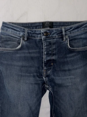 NEUW Jeans lou slim midblue - Jeans med raka och smala ben från Neuw. Jeansen är i en klassisk femficksmodell med en medelhög midja.  * Bältesöglor * Logopatch bak i linningen * Ringdetalj framtill i linningen * storlek 34:34 * Material: 99% Bomull 1% Elastan *Ordinarie pris ligger på 1399kr