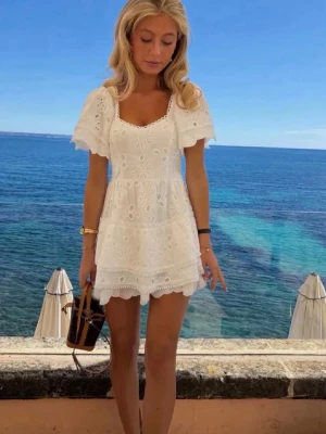 Vit kort klänning, Student - Söt vit kortklänning med broderade spetsdetaljer och volangkant. Är från meet me there i storlek S/M, passar mig perfekt som har S i storlek. Helt oanvänd med prislapp, då jag valde en annan klänning till studenten. Men så fin verkligen!!🩷🩷🩷