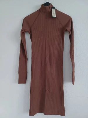 Rib slim dress  - Stylish G-Star ribbed slim-fit dress with long sleeves and a raised neckline. Features extended cuffs with thumbholes for a comfortable and modern look.  Size: XS / 34 Condition: New with tags Colour: Brown Material: Cotton Original price: 850 SEK  Perfect for everyday wear, work, casual outings, dinners or creating a stylish fitted look.  📦 Ships within 48h
