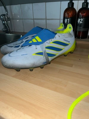 Adidas Predator Ag elit skor - Säljer ett par Ag elit fotbollsskor från adidas. Skorna är använda ungefär 5 gånger med inga större defekter förutom att dom har blivit lite mörkare pga konstgräs. Skriv om du har npgon fundering