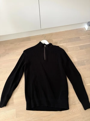 Svart stickad tröja med halv dragkedja - Säljer en svart stickad tröja från H&M med ribbad stickning. En perfekt tröja för en avslappnad lock eller en uppklädd lock med tillexempel skjorta under! 