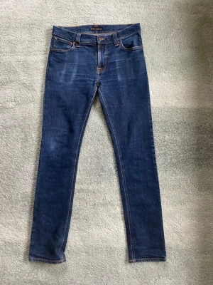 Nudie jeans thinn finn - Ett par snygga marinblåa Nudie jeans i modellen thinn Finn org dry twill. Storlek 33/34 men de sitter mindre, han på bilden är 178. De är i gott skick utan defekter, och har ett par riktigt snygga fades. Har du några frågor? Fråga på!