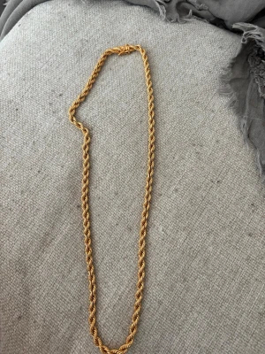 Guldfärgat kedjehalsband från Kejsar - Säljer ett snyggt guldfärgat halsband från Kejsar med tvinnad kedja. Lång 50cm 4mm bredd 