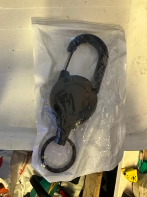 Svart karbinhake med nyckelring - Praktisk svart karbinhake i metall med rund nyckelring. Perfekt att fästa på väskan eller byxan för att hålla koll på nycklar eller små accessoarer. Enkel och stilren design som passar till det mesta.