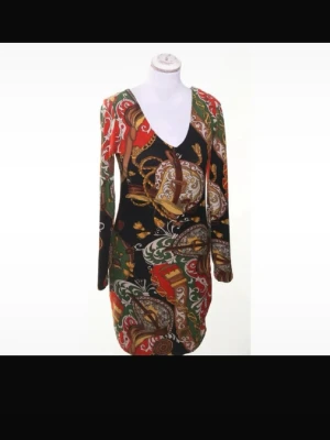 Fashion Hy-H Y2K Klänning Retro Paisley Djup V-ringning Bodycon Stretch Stl S - Supersnygg figurnära klänning från Fashion Hy-H med djup V-ringning fram och bak, långa ärmar och stretchigt material. Det färgstarka retroinspirerade mönstret ger en tydlig Y2K-känsla. Passar dig med cirka XS- S (36). Mycket fint skick utan synliga defekter. Perfekt till fest, middag eller en trendig vardagslook. Jag erbjuder bundlerabatt vid köp av flera plagg.