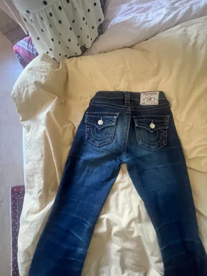 Mörkblå True Religion jeans -  snygga true religion jeans i modellen Becca mid waist och lite slitna längst ner på byxan men annars i bra skick pris går att diskutera