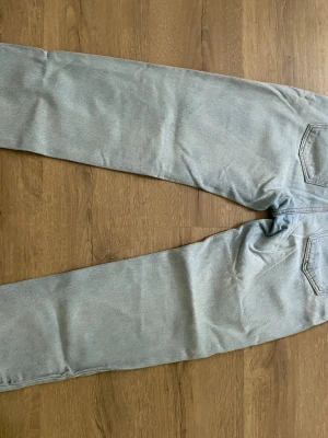 Ljusgrå raka jeans - Säljer ett par ljusblåa jeans från Grunt med storlek 26 