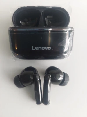 Svarta trådlösa in-ear hörlurar Lenovo - Snygga svarta trådlösa in-ear hörlurar från Lenovo med laddningsetui. Hörlurarna har en stilren design med blanka detaljer och silikonproppar för bra passform. Perfekta för musik, poddar och samtal på språng.