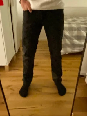 Svarta slim fit jeans - Säljer ett par svarta slim fit jeans med klassisk femficksdesign. Jeansen har normal midja och smal passform hela vägen ner. Perfekta för dig som gillar en clean och enkel stil.
