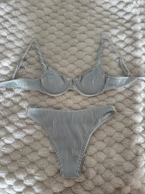 Randig bikini svart och vitt randig - Snygg bikini med smala band och svart, vita ränder. Överdelen har bygel och justerbara axelband.