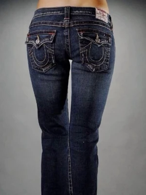 True Religion blå jeans med fickdetaljer - Säljer ett par blå jeans från True Religion med ikoniska kontrastsömmar och stora fickor bak med lock och silverknappar. Klassisk patch med logga bak i midjan. Snygg passform och coola detaljer som sticker ut. Längden är 99 cm
