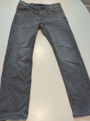 Grå jeans från Jack & Jones - Snygga grå jeans från Jack & Jones i modellen Tapered Mike. Helt ny skick 