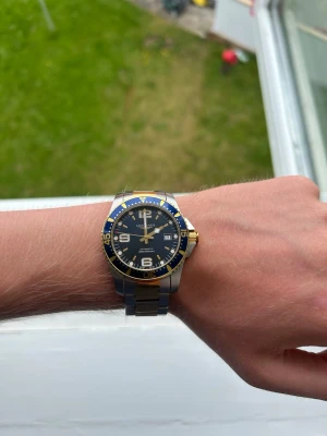 Longines blå och guld klocka - Snygg longines L3.742.3, väldigt bra skick endast små små hårslingor på armbandet som knappt går att se. Ingår certifikat och låda.
