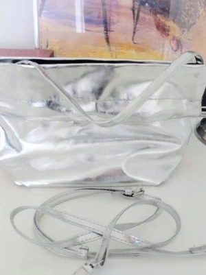 Nya Klairs Silver Bag Pouch handväska  - Helt ny och aldrig använd Nya Klairs Silver Bag Pouch handväska  Lite tjockare vadderad - fint svart siden inuti Mått 28 x 18 cm hög och 11 cm bred