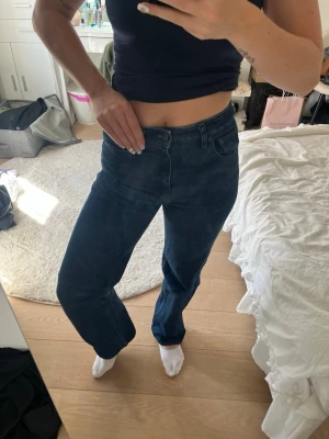 Mörkblå raka jeans Filippa K - Snygga mörkblå jeans från Filippa K med rak passform och klassisk femficksdesign. Jeansen har hög midja och är tillverkade i ett stadigt denimtyg. Perfekta för en clean och stilren look.
