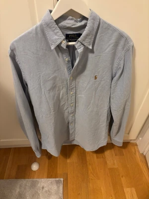 Ljusblå skjorta från Polo Ralph Lauren - En schysst skjorta ifrån Ralph Lauren i storlek L men i slim fit så passar för M. Pris går att diskuteras så bara att buda på.
