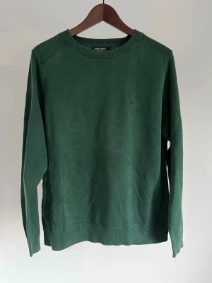 Nautica Mörkgrön Bomullströja Crew Neck 100% Bomull | Herr M - Nautica Mörkgrön Bomullströja Crew Neck 100% Bomull | Herr M Storlek: M Färg: Forest Green Passform: Regular fit  Krage: Rund hals (crew neck) Material: 100% bomull Skick: Denna tröja är i ett väldigt fint skick utan defekter  Nypris cirka: 900 kr