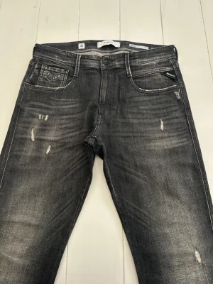 Washed Svarta Replay  - Säljer ett par svarta jeans från Replay med slitningar och washed svart färg
