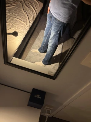 Blå raka jeans med slitningar - Säljer ett par klassiska blå jeans med raka ben och diskreta slitningar. Jeansen har fem fickor och normal midja. Materialet är denim i bomull och de har en avslappnad passform som passar till det mesta.