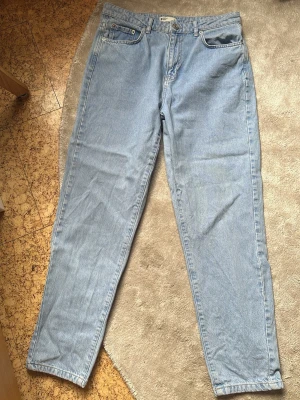 Gina Tricot "Perfect Jeans" – Ljusblå / Strl 42 - Klassiska ljusblå jeans från Gina Tricot i modellen "Perfect Jeans". Raka ben med en lätt avsmalnande siluett nedtill (mom fit/straight fit) och hög/normal midja. 