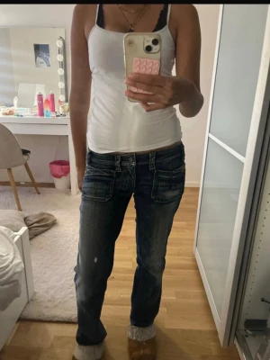 Diesel Vintage Jeans -  Snygga vintage Diesel-jeans i mörkblå denim med klassisk Y2K/00-talsstil. Jeansen har flera detaljerade fickor framtill och baktill, kontrastsömmar och Diesel-detaljer.  Säljs eftersom de inte längre används. Se bilder för skick och detaljer. Kan inte hitta dessa jeans någonstans.   ! Storlek 29 !  Jag är 161 och dem är lite oversized vid midjan så dem faller ner lite.  