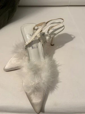 Vita pumps med fjädrar och smal klack - Snygga vita pumps från Shein med spetsig tå, smal klack och fluffiga fjädrar framtill. 