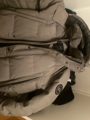Grå vinterjacka  - Grå canada goose jacka i storlek s.den har använts i 3 vintrar och missfärgats.men är annars i ganska bra skick