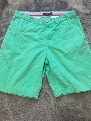 Tommy Hilfiger Chinosshorts - Fräscha och stilrena gröna chinosshorts från Tommy Hilfiger. Klassisk modell med fina detaljer och hög kvalitet.