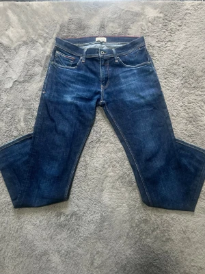 Tommy Hilfiger Denim Jeans (W32/L32) - Snygga mörkblå jeans från Hilfiger Denim med fin tvätt och klassiska detaljer.