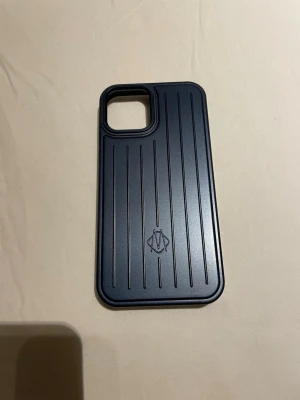 Mörkblått Rimowa mobilskal till iPhone 12 - Använt 1 gång. Passar till iPhone 12
