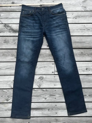 Jack & Jones jeans slim fit - Storlek: 29/32 Snygg mörkblå tvätt som ger dessa jeans schyssta detaljer och en unik look. Modell: Slim fit. Bra skick mycket sällan använda. Hör av er vid frågor eller behov av fler bilder! Mvh Axel