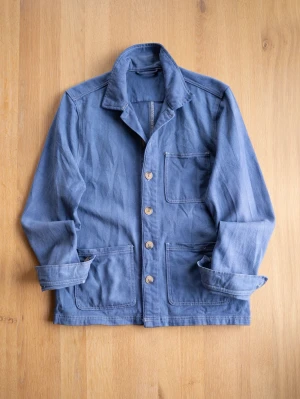 Blue Chore Jacket, size S - Säljer en blå skjorta i bomull med tre stora fickor framtill och knappar hela vägen. Skjortan har klassisk krage och långa ärmar som kan vikas upp för en mer avslappnad look. Perfekt för dig som gillar enkel och stilren design.