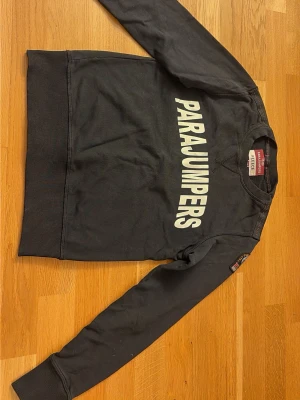 Svart parajumpers sweatshirt  - Jag säljer denna svarta parajumpers fleece sweatshirten med stort tryck på bröstet som är i storlek y.s (barnstorlek) och är i fint skick💕 använd enstaka gånger💕 skriv vid minsta fundering!!