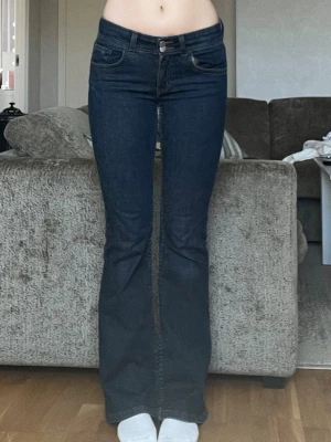 Mörkblå bootcut jeans - Säljer ett par mörkblå bootcut jeans med medelhög midja i storlek s och längd 32 från Bik Bok. Väldigt stretchiga och sköna att ha på sig🤎