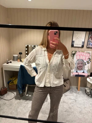 Vit broderad blus med spetsdetaljer - Säljer en vit blus från Zara med broderade detaljer och spetsinslag. Blusen har knappar framtill, krage och långärmade ärmar. 