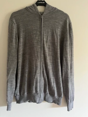 Grå zip hoodie i merinoull  - En stilren grå merinoull hoodie med dragkedja i super fint skick.