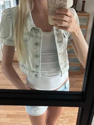 Kort ljus jeansjacka med puffärm - Säljer en supersöt croppad ljusblå jeansjacka med puffärmar och kort ärm. Köpt på plick men inte kommit till användning tyvärr. Finns ingen lapp så kan inte se storlek eller märke, den passar som en xs och den är i fint skick🤍🤍