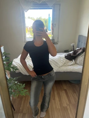 Grå raka jeans med låg midja - Säljer ett par grå jeans med rak passform och låg midja. Jeansen har klassiska fickor både fram och bak samt en lätt tvättad look. Perfekta för dig som gillar en avslappnad och trendig stil.