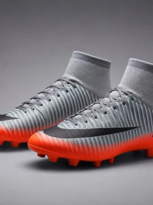 Grå-röda fotbollsskor med strumpkrage - Snygga fotbollsskor från Nike i grått med svart swoosh och röda detaljer på sulan. Skorna har en hög strumpkrage för extra stöd runt ankeln och ribbad ovandel för bättre bollkontroll. Perfekta för konstgräs och snabba vändningar på planen.