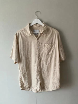 Beige kortärmad skjorta - Beige kortärmad skjorta i storlek M
