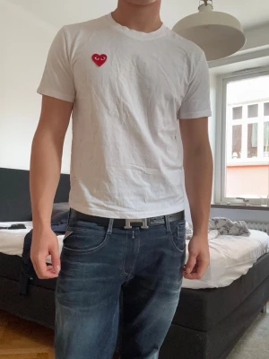 Vit Cdg tshirt - Säljer en vit cdg tröja som är tvärsnygg och är perfekt till alla dina outfits. Man kan inte gå fel med en vit tisha!! Kom pm för frågor!! Skit bra skick också!