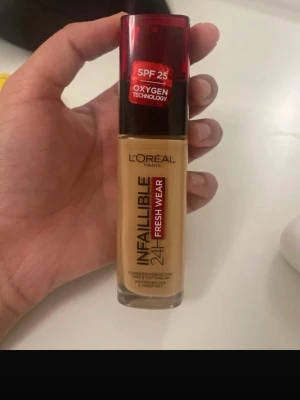 L'Oréal Infallible 24H Fresh Wear Foundation - L'Oréal Infallible 24H Fresh Wear Foundation med SPF 25 och Oxygen Technology. Kommer i en glasflaska med röd plastkork och pump. Färgen är en varm beige ton som ger ett naturligt resultat och lång hållbarhet.